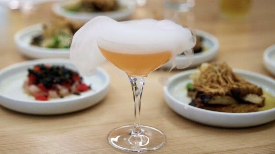 A fancy cocktail with smoke pouring out of the top